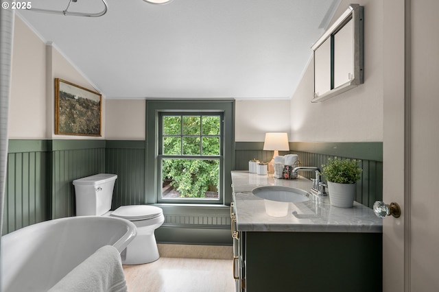 2815 NE 35th Ave, Portland, OR 97212 - bathroom featuring lofted ceiling, toilet, vanity, a wainscoted wall, and a soaking tub