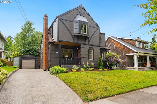 2815 NE 35th Ave, Portland, OR 97212 - english style home with covered porch, a front yard, an outdoor structure, and asphalt driveway