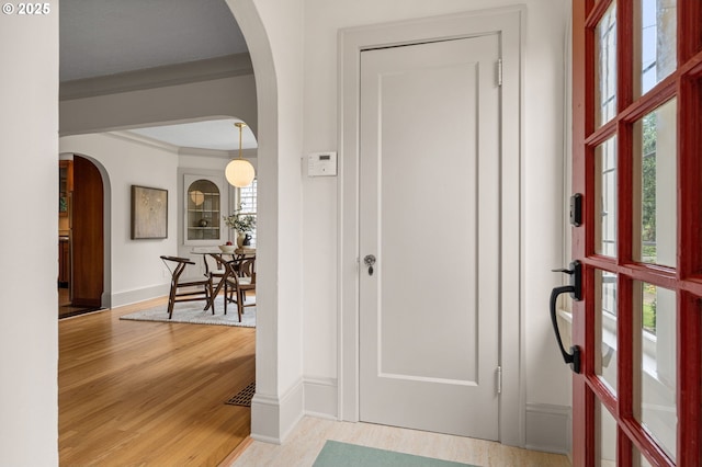 2815 NE 35th Ave, Portland, OR 97212 - foyer entrance featuring arched walkways, light wood-type flooring, baseboards, and crown molding