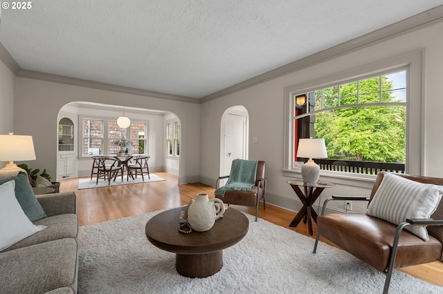 2815 NE 35th Ave, Portland, OR 97212 - living room with arched walkways, wood finished floors, plenty of natural light, a textured ceiling, and crown molding