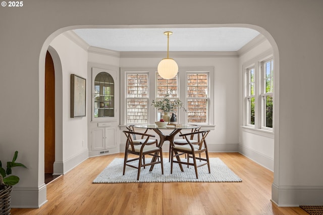2815 NE 35th Ave, Portland, OR 97212 - dining space featuring light wood-style flooring, arched walkways, baseboards, and crown molding