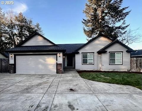 ranch-style home with a garage and a front yard