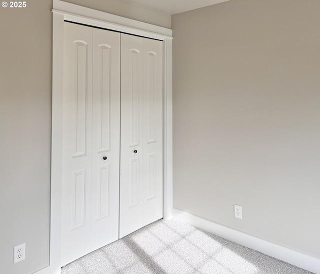 unfurnished bedroom featuring a closet and light carpet