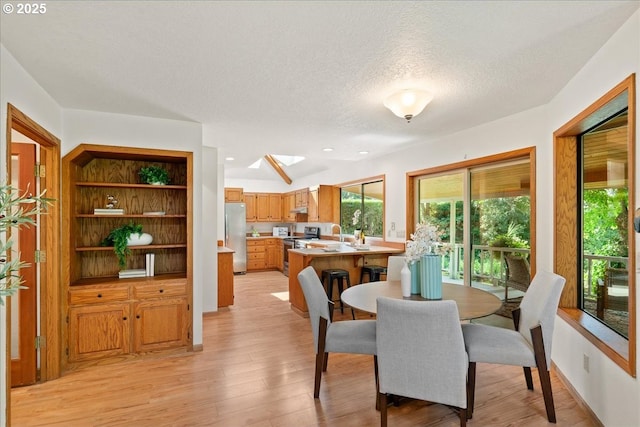 115 Willow St, Silverton, OR 97381 - dining room featuring a skylight, light wood-style floors, and a textured ceiling