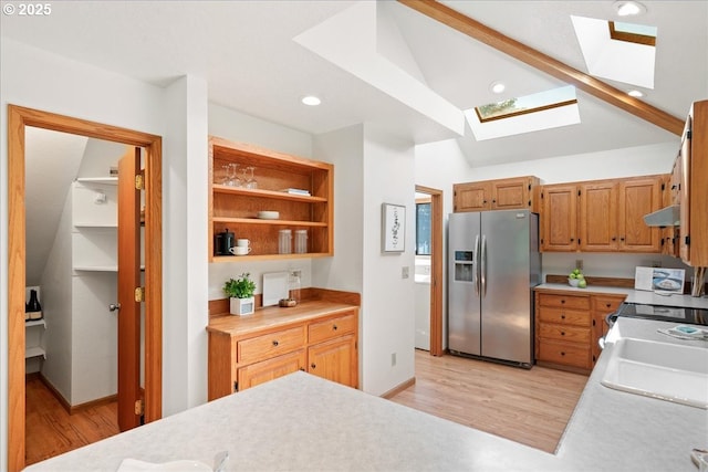 115 Willow St, Silverton, OR 97381 - kitchen featuring stainless steel fridge with ice dispenser, a skylight, light wood-style floors, under cabinet range hood, and light countertops