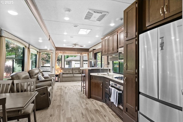 115 Willow St, Silverton, OR 97381 - kitchen featuring stainless steel appliances, open floor plan, light countertops, light wood finished floors, and plenty of natural light