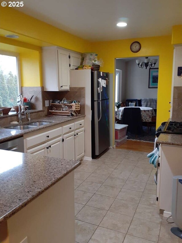 1347 NE Paloma Ave, Gresham, OR 97030 - kitchen with freestanding refrigerator, white cabinets, light stone countertops, decorative backsplash, and recessed lighting