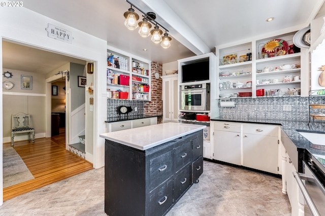 kitchen featuring a kitchen island, oven, dark cabinetry, white cabinetry, and open shelves