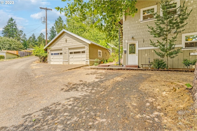 view of front of property with a detached garage and an outbuilding