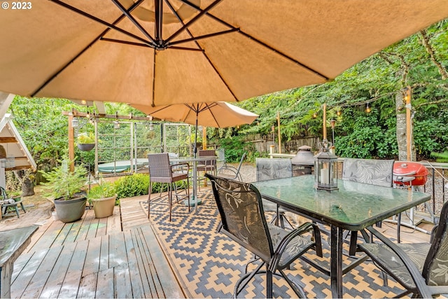 wooden terrace featuring outdoor dining area and fence