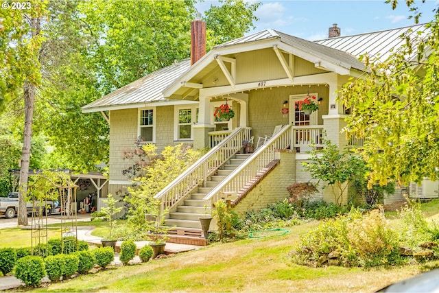 view of front of property featuring metal roof, a chimney, and a standing seam roof