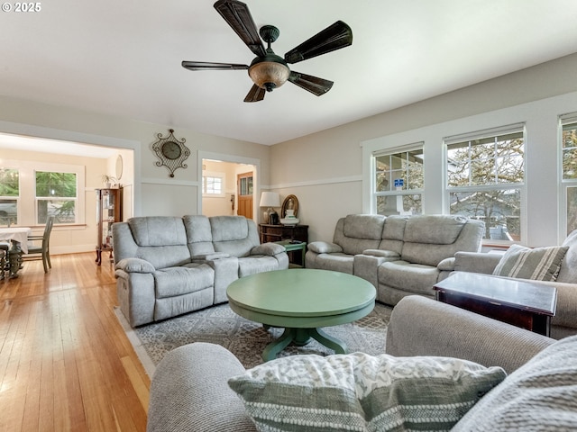 living area with light wood-type flooring and ceiling fan