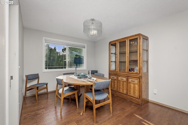 5355 SW 205th Ct, Beaverton, OR 97078 - dining room featuring dark wood-style flooring, a chandelier, a textured ceiling, and baseboards