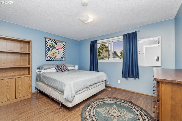5355 SW 205th Ct, Beaverton, OR 97078 - bedroom with wood finished floors, a textured ceiling, and baseboards