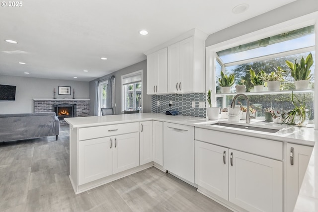 5355 SW 205th Ct, Beaverton, OR 97078 - kitchen featuring a sink, a brick fireplace, light countertops, light wood finished floors, and recessed lighting