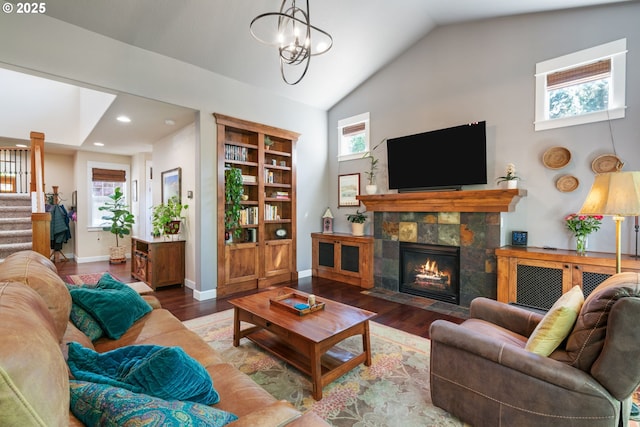 living room featuring stairs, wood finished floors, lofted ceiling, a tiled fireplace, and recessed lighting