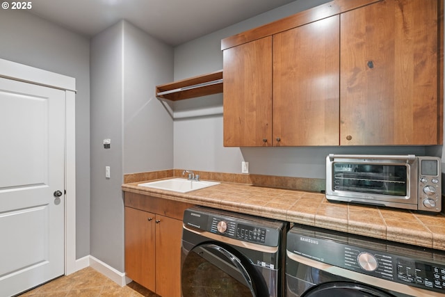 laundry room featuring washer and clothes dryer, cabinet space, baseboards, and light tile patterned floors