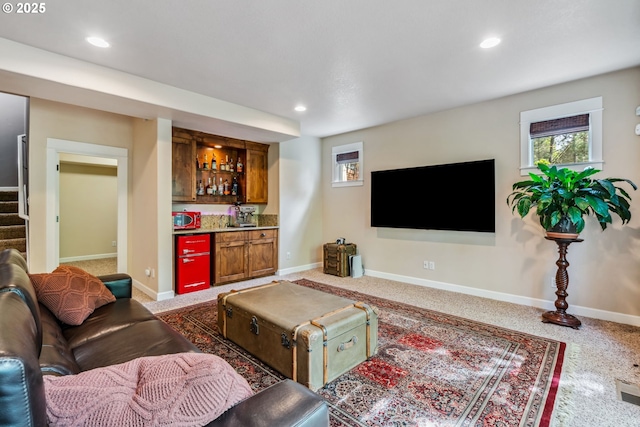 living area with bar with sink, stairway, recessed lighting, baseboards, and plenty of natural light
