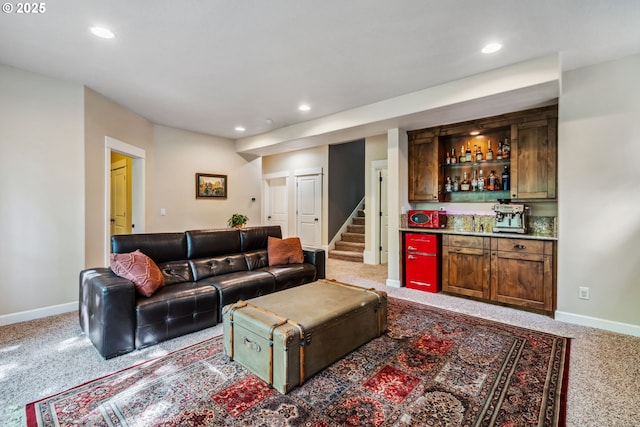 living room featuring a bar, light carpet, baseboards, recessed lighting, and stairway