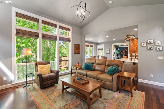 living area featuring baseboards, dark wood-style floors, recessed lighting, a chandelier, and high vaulted ceiling