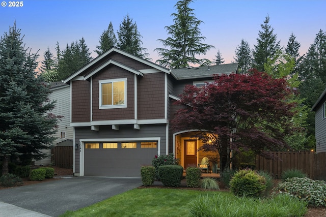 view of front facade with fence, driveway, and a garage