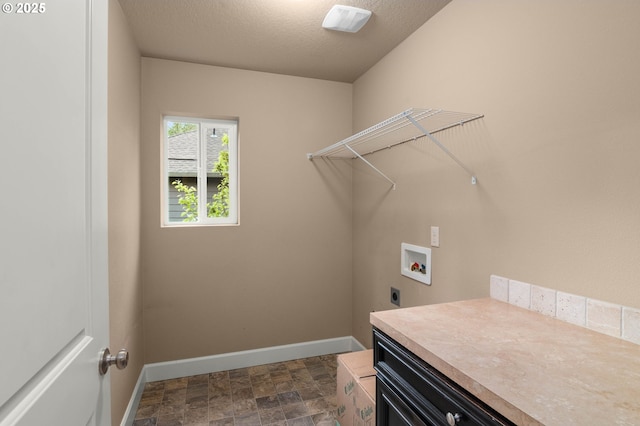 laundry area with stone finish floor, laundry area, electric dryer hookup, baseboards, and hookup for a washing machine