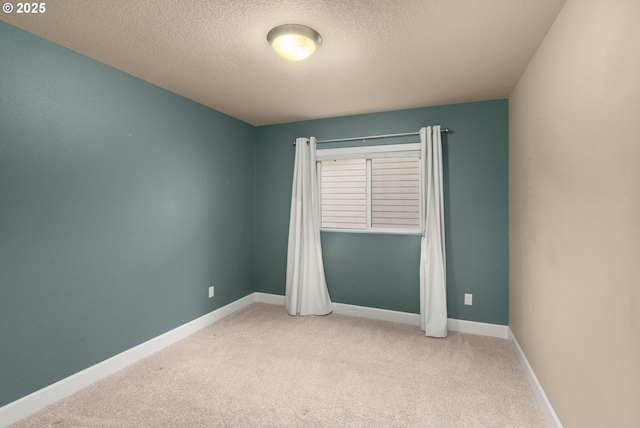 unfurnished room featuring carpet floors, baseboards, and a textured ceiling