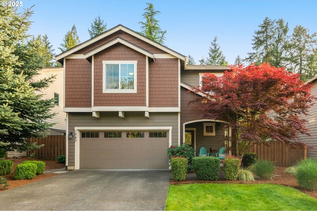 craftsman-style house featuring a garage, fence, and driveway