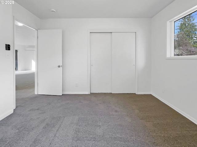 unfurnished bedroom with a closet, baseboards, and carpet