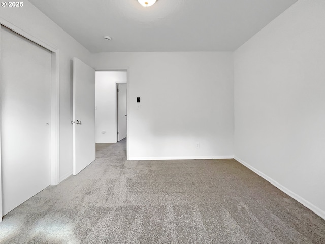 carpeted empty room featuring baseboards