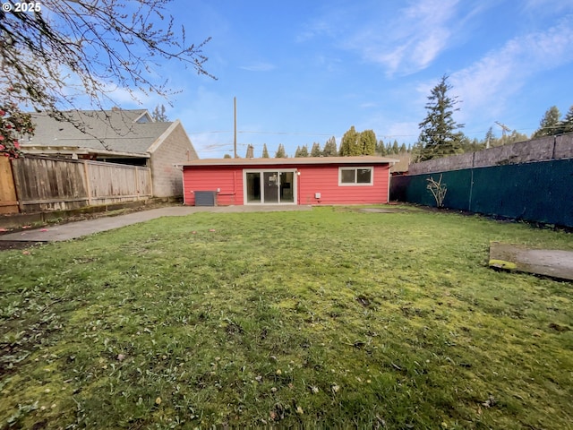 rear view of property with a lawn, central AC, and a fenced backyard