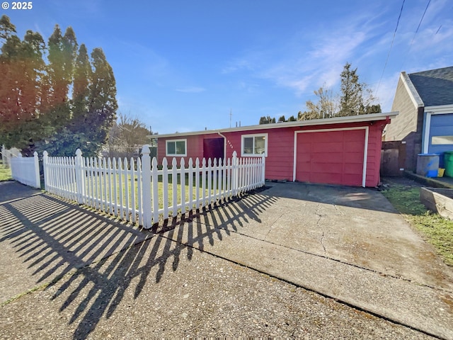 ranch-style home with a fenced front yard, a garage, and driveway