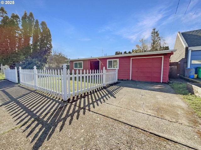 ranch-style home with a fenced front yard, driveway, and a garage