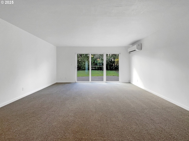 unfurnished room with a wall unit AC, carpet flooring, and baseboards