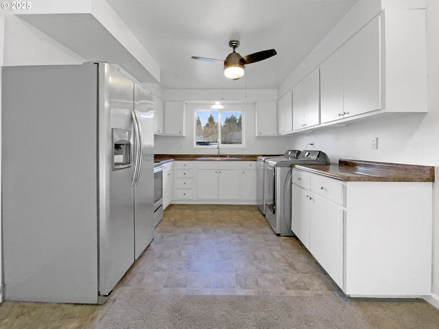 kitchen with dark countertops, stainless steel refrigerator with ice dispenser, white cabinets, a ceiling fan, and separate washer and dryer