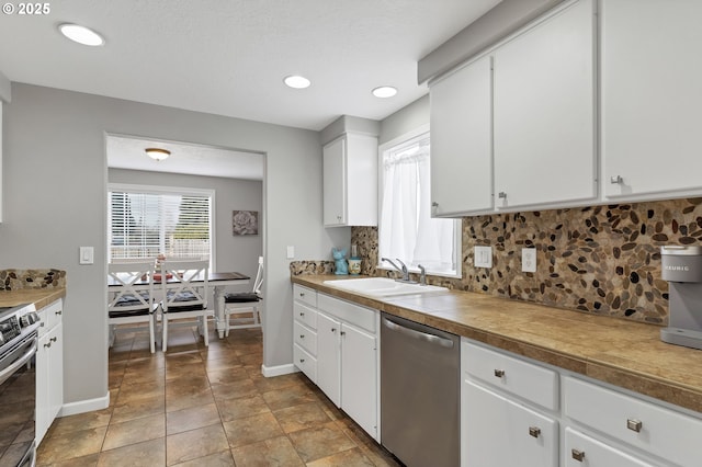 kitchen with white cabinetry, appliances with stainless steel finishes, sink, and backsplash