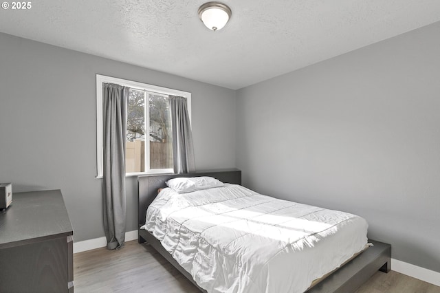 bedroom featuring light hardwood / wood-style flooring and a textured ceiling