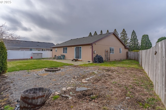 back of house featuring an outdoor fire pit, a patio area, and a lawn