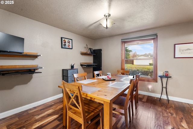 dining space featuring a textured ceiling and dark hardwood / wood-style flooring