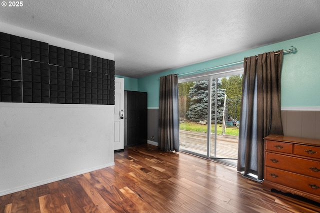 unfurnished room featuring a textured ceiling and dark hardwood / wood-style flooring