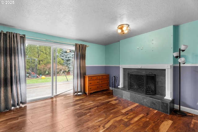 unfurnished living room with a textured ceiling, a fireplace, and hardwood / wood-style flooring