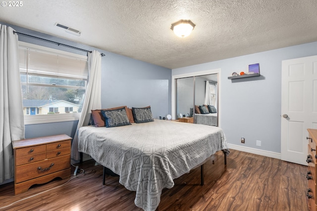 bedroom featuring a closet, a textured ceiling, and dark wood-type flooring