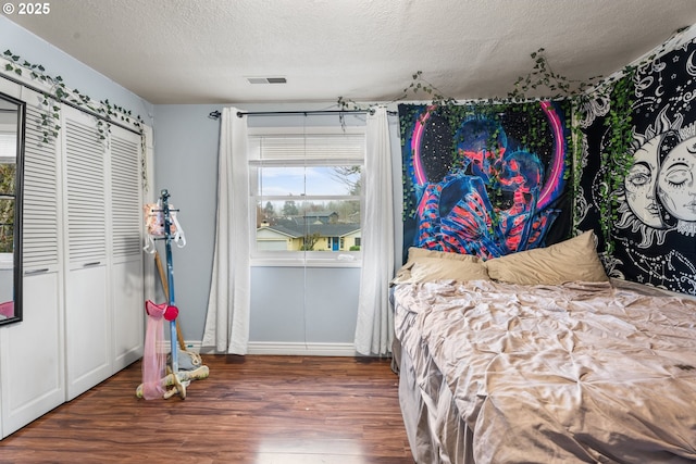 bedroom with dark hardwood / wood-style flooring and a textured ceiling