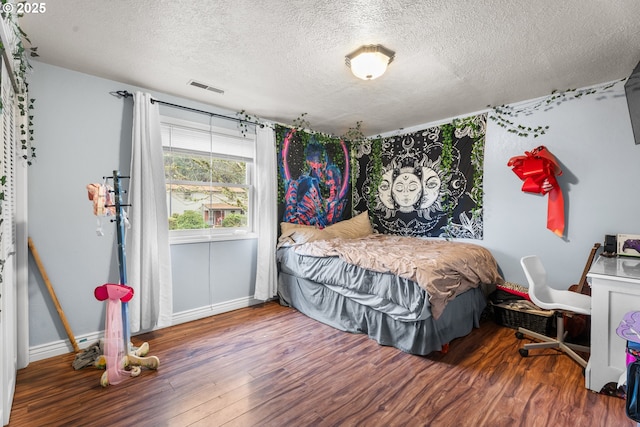 bedroom featuring a textured ceiling and hardwood / wood-style floors