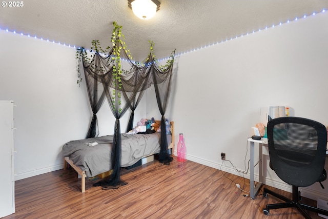 bedroom with a textured ceiling and hardwood / wood-style floors