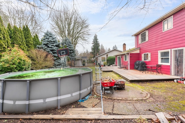 exterior space featuring a fire pit and a pool side deck