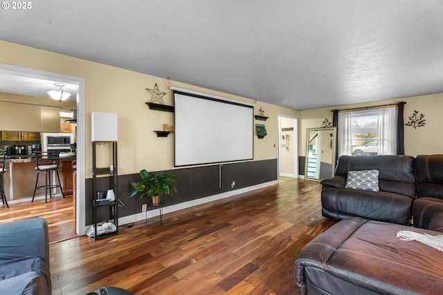 cinema room featuring a textured ceiling and dark hardwood / wood-style floors