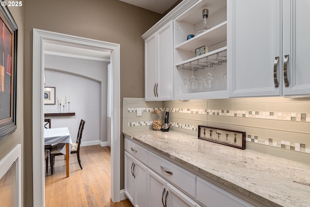 352 SE 14th Pl, Canby, OR 97013 - kitchen with open shelves, backsplash, light wood finished floors, white cabinetry, and baseboards