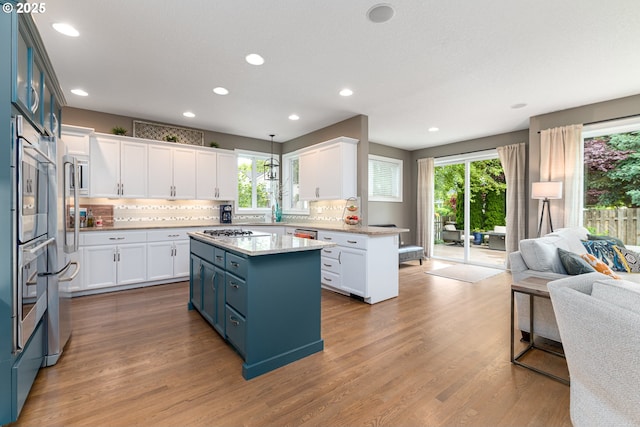 352 SE 14th Pl, Canby, OR 97013 - kitchen with open floor plan, plenty of natural light, blue cabinets, gas cooktop, and recessed lighting