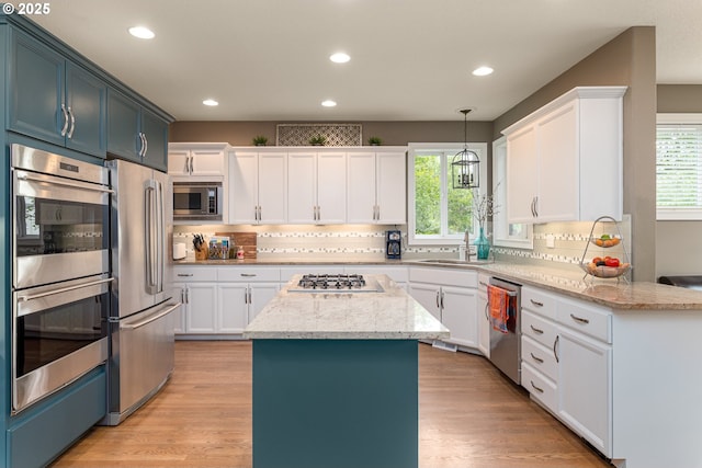 352 SE 14th Pl, Canby, OR 97013 - kitchen with appliances with stainless steel finishes, plenty of natural light, a center island, decorative backsplash, and recessed lighting